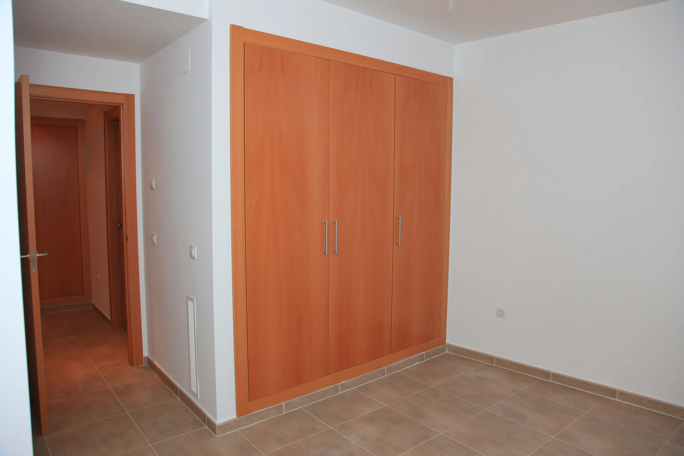 Dormitorio con armario empotrado de tres puertas