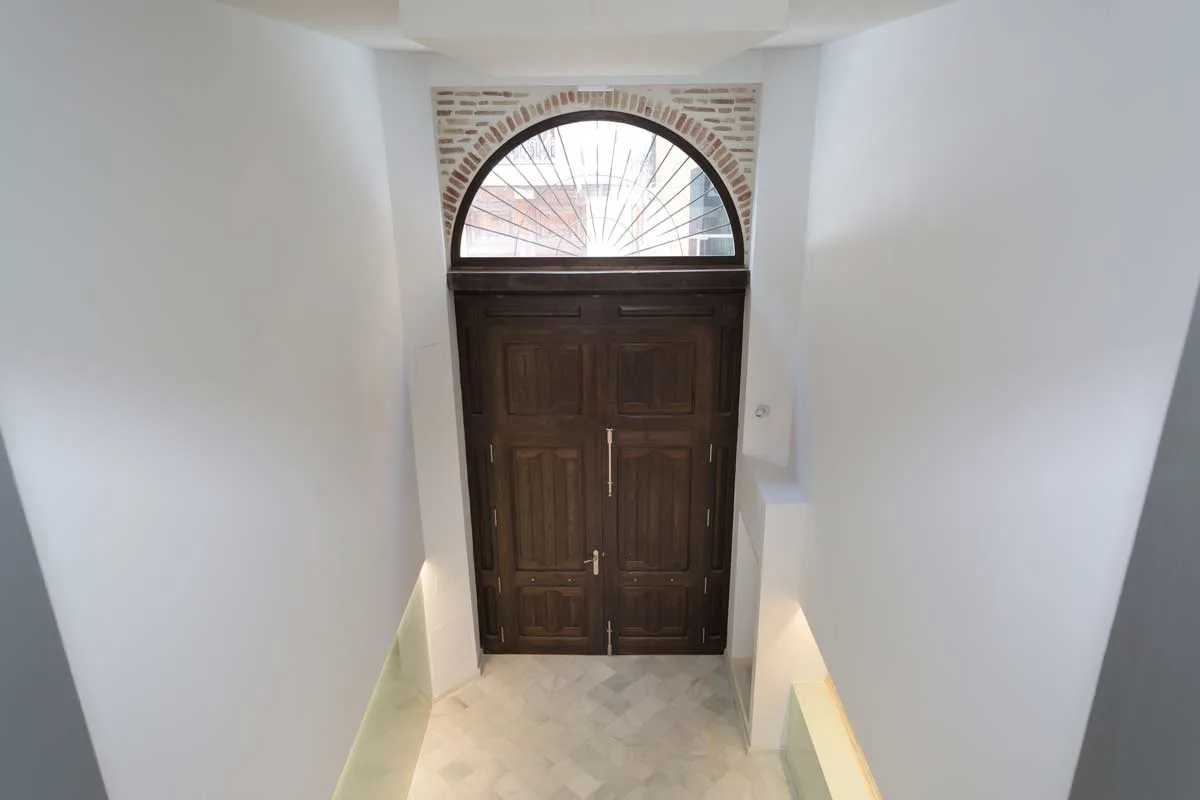 La puerta de entrada vista desde el interior, con el arco de ladrillo visto