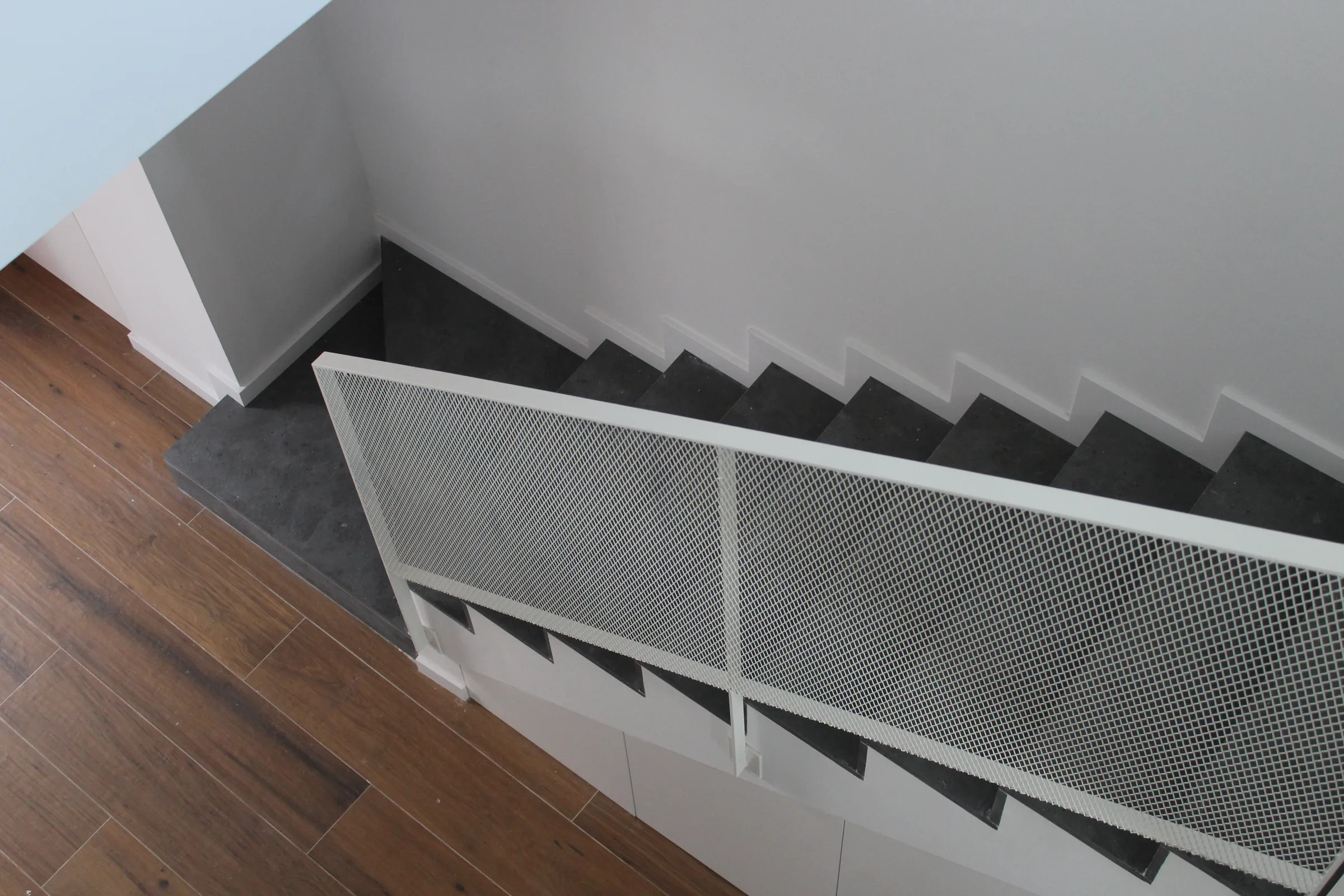 Escalera con peldaños de terrazo y rejilla de climatización