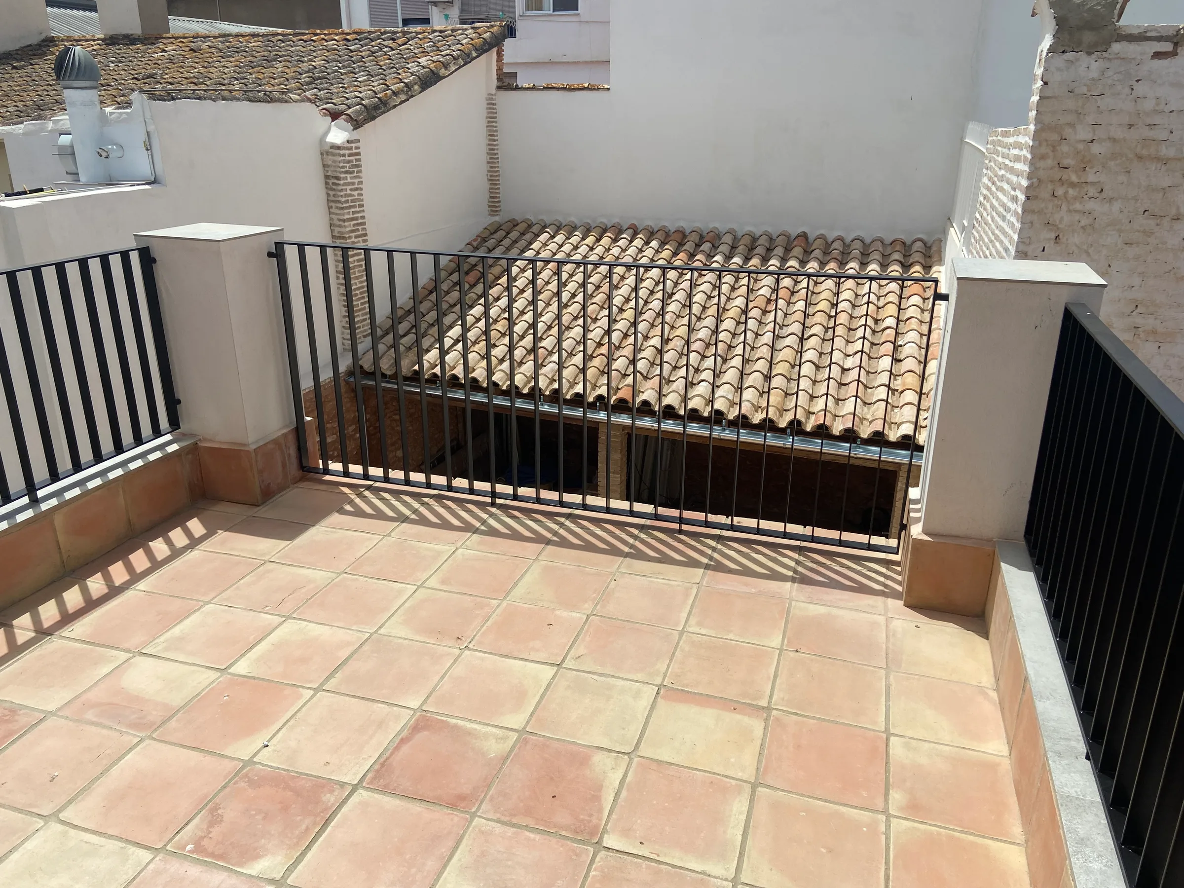 Terraza con pavimento cerámico y rejería recuperada
