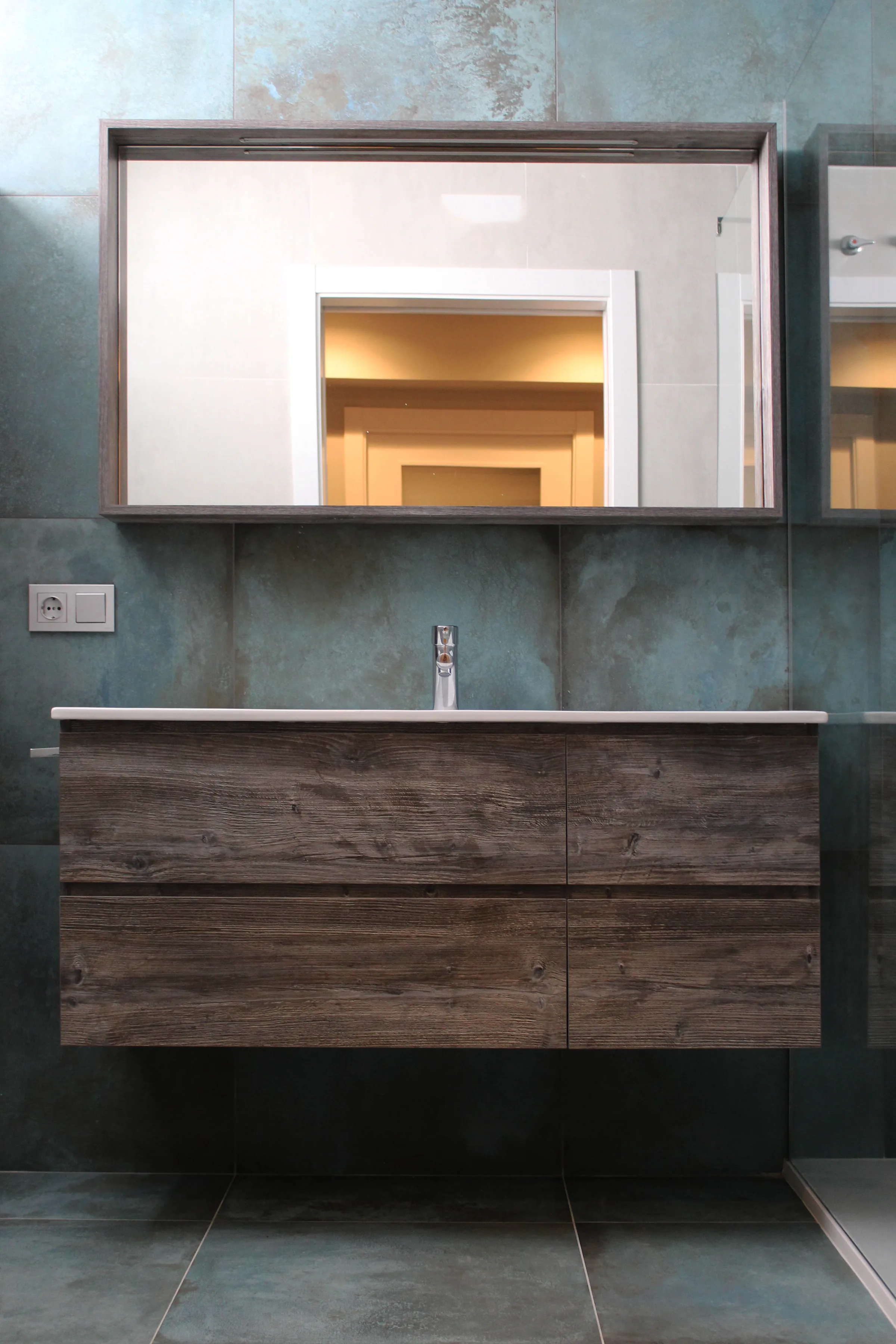 Baño principal con mueble suspendido y espejo enmarcado