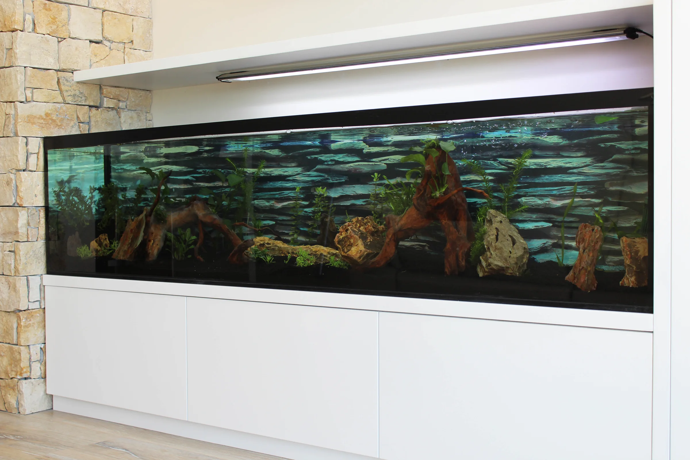 Mueble de obra a medida con el acuario integrado bajo el televisor