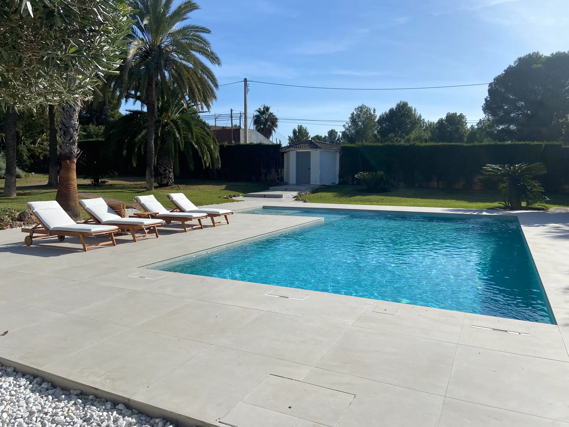 La piscina con el nuevo pavimento y la zona de tumbonas