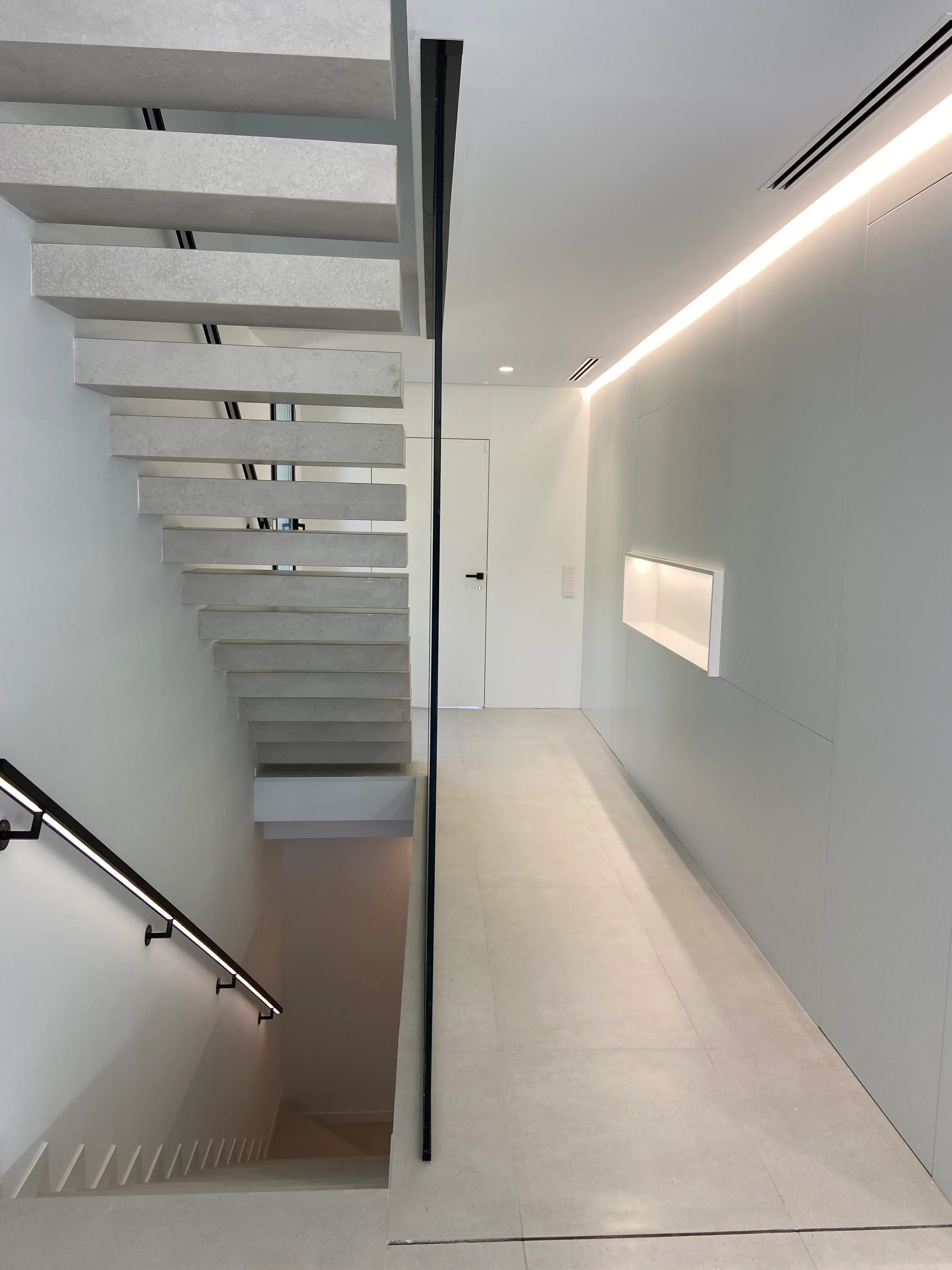 Escalera suspendida con barandilla de cristal