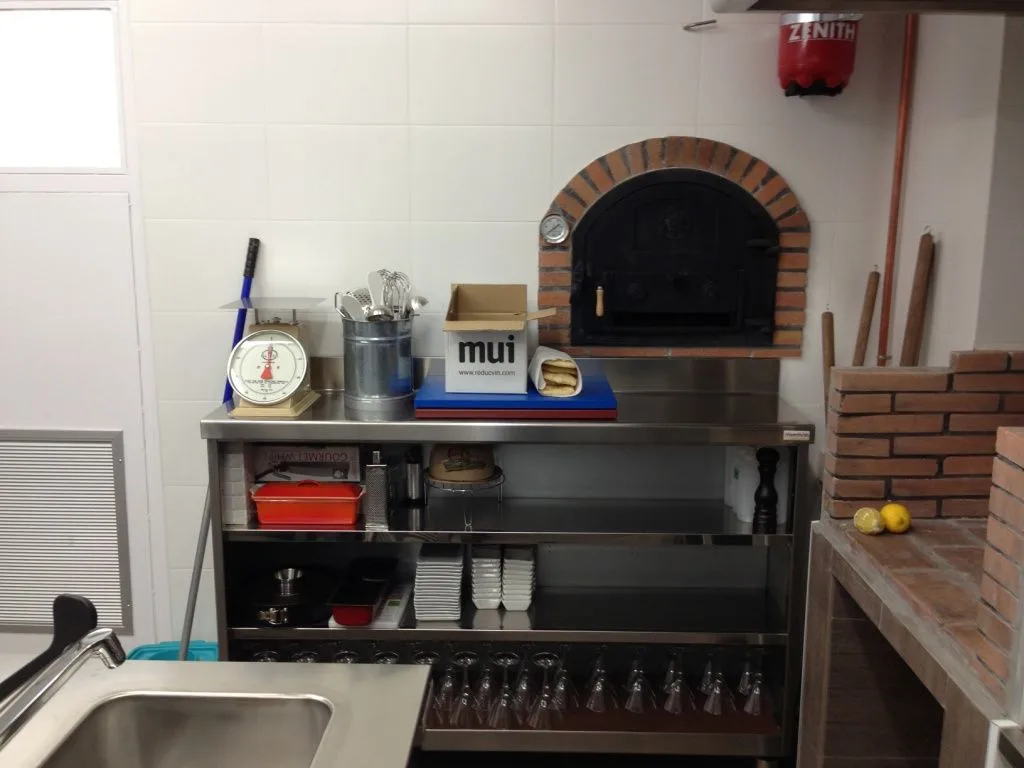 Horno moruno de ladrillo junto al mostrador de acero inoxidable